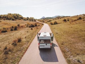 Couple dancing out of a campervan to road trip songs