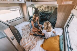 Camping with kids in an RV, two girls playing on the bed