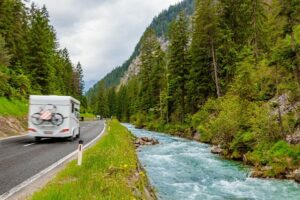 campergids bij een kanaal en bos