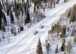Two campervans parked in the snow during a Winter Olympics 2026 campervan trip in the Italian Alps.