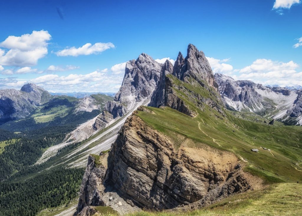 Italian Alps campervan adventure at Seceda ridgeline with twisted Odle mountains and hiking trail
