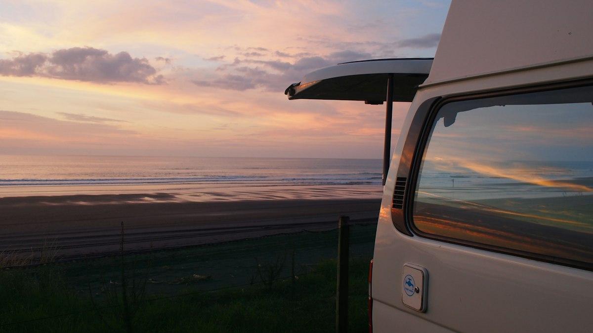 Campervan parked at sunset in Mokau, New Zealand