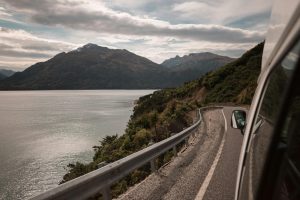 View from a campervan window along a lakeside road in New Zealand