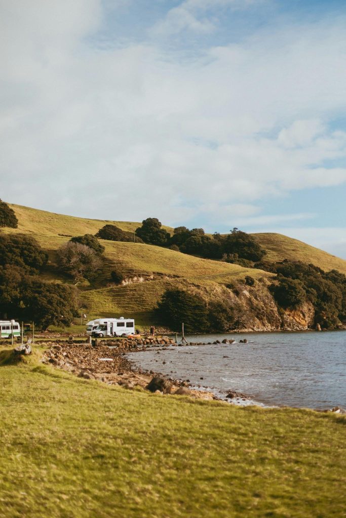 Campervans parked at a waterside campsite in New Zealand