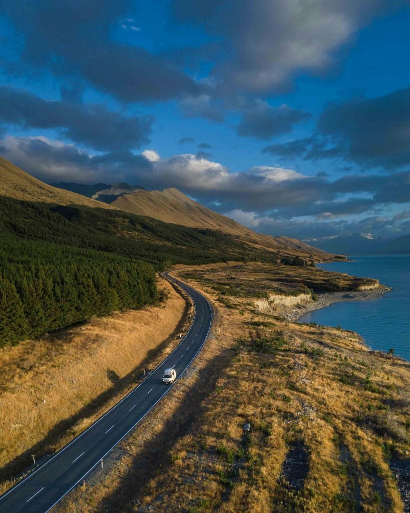 Aerial view of a road winding past forest and coast in New Zealand