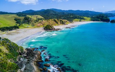 Aerial view of a turquoise bay and beach on New Zealand’s North Island coast in summer