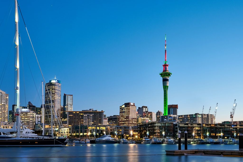 Auckland skyline and Sky Tower lit up over the harbour at dusk