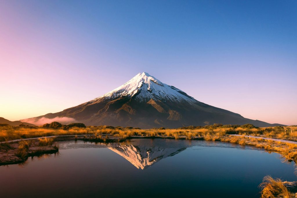 Snow-capped Mount Taranaki reflected in the Pouakai Tarns at sunrise on New Zealand’s North Island